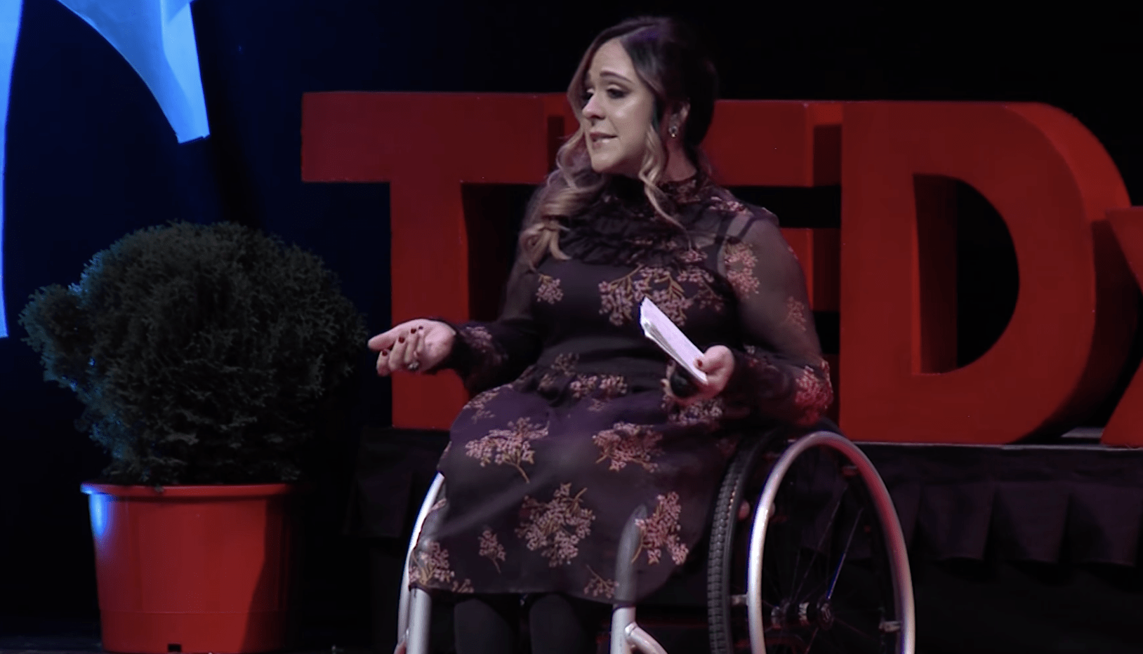 A lady in a wheelchair talks on stage and tells listeners I can do